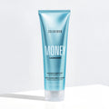 Blue shampoo bottle labeled 'Color Wow Money Laundering Glossing Conditioner' on a white background