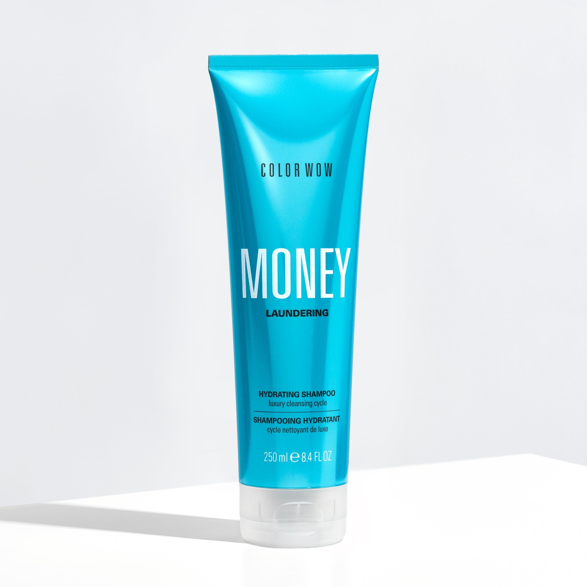 Blue shampoo bottle labeled 'Color Wow Money Laundering Hydrating Shampoo' on a white background